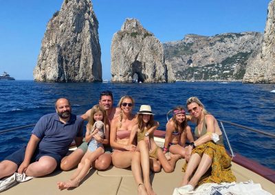 foto di famiglia a largo dei Faraglioni di Capri, con barca a noleggio