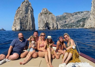 foto di famiglia a largo dei Faraglioni di Capri, con barca a noleggio