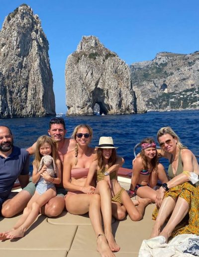 foto di famiglia a largo dei Faraglioni di Capri, con barca a noleggio